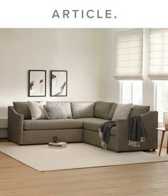 a living room filled with furniture on top of a hard wood floor covered in white rugs