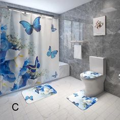 a bathroom with blue and white butterflies on the shower curtain, rugs and toilet paper