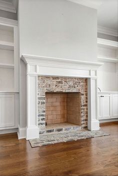 an empty living room with a brick fireplace