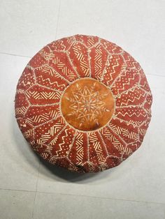 a red and white decorative pillow sitting on top of a floor