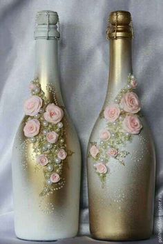 two champagne bottles decorated with pink roses and pearls