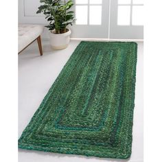 a green rug on the floor in front of a window