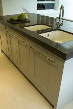 a kitchen counter with two sinks and a dishwasher