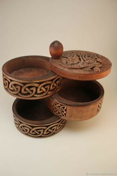 three wooden bowls with carved designs on them