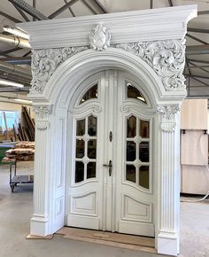 an ornately decorated white double door in a warehouse