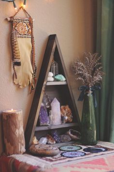 a table topped with lots of different items next to a wall mounted shelf filled with candles