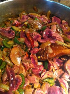 a pan filled with meat and vegetables on top of a stove