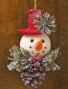 a snowman ornament hanging from a wooden door with pine cones and needles