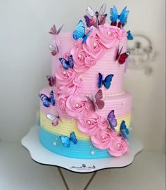 a multi layer cake decorated with pink flowers and butterflies