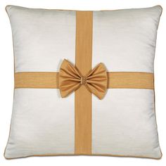 a white and gold pillow with a bow on it