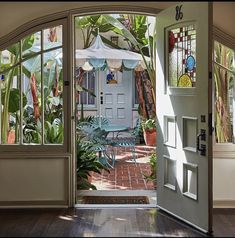 an open door leading to a patio with chairs and umbrellas