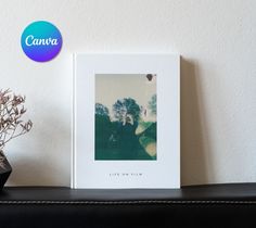 a white photo frame sitting on top of a black shelf