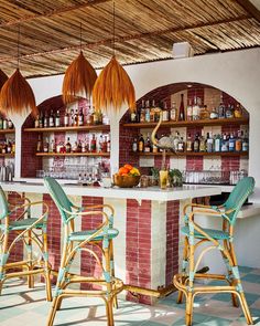 an outdoor bar with wicker chairs and hanging lights