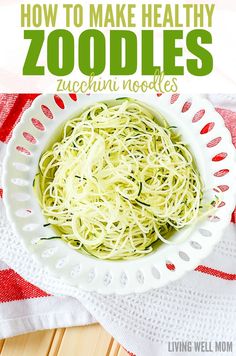 a white bowl filled with zucchini noodles on top of a red and white towel