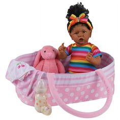 a baby doll sitting in a pink basket