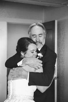 a man and woman hugging each other in a room