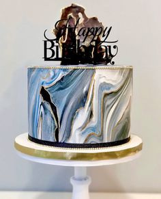 a marbled birthday cake with the words happy birthday on top is decorated with black and white icing