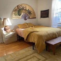 a bed sitting in a bedroom next to a window with a fan on the wall