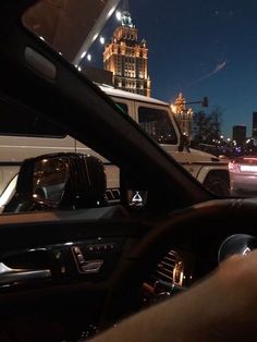 the interior of a car is shown at night with traffic in the city behind it