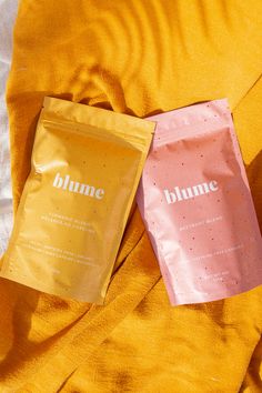 two bags of bumme are laying on a bed