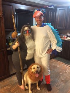 two people in costumes pose with a dog