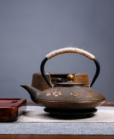 an old tea kettle sitting on top of a table next to a small wooden box