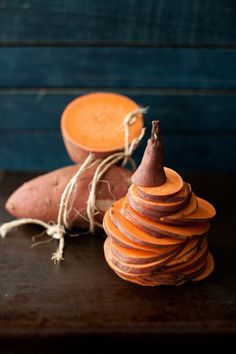 two sweet potatoes sitting next to each other on top of a wooden table with twine