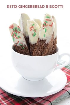 a cup filled with cake and frosting on top of a white saucer