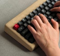 a person typing on a black and red keyboard