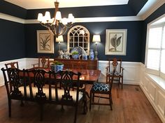 a dining room with blue walls and wooden floors