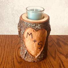 a wooden candle holder with a heart on it