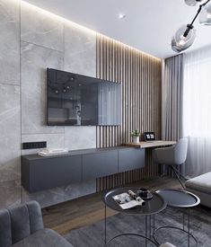 a modern living room with grey furniture and wood paneling on the walls, along with a large flat screen tv mounted to the wall