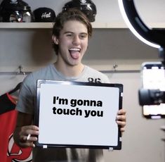 a young man holding up a sign that says i'm gonna touch you