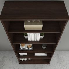 a book shelf with books and other items on it in an empty room that appears to be for display