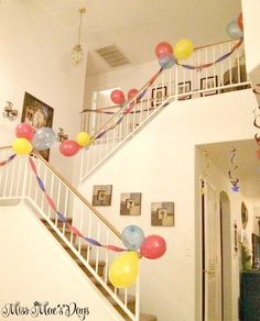 balloons and streamers are hanging from the banisters in this entryway decorated for a birthday party