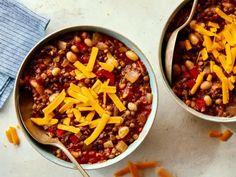 two bowls filled with chili cheese and beans