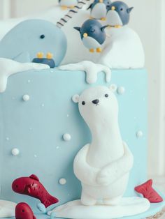 there is a cake that looks like a polar bear and fish on the bottom layer