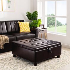 a living room with a brown leather couch and ottoman