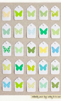 small butterfly shaped tags with different colors and patterns on the top one is green, yellow, blue, white, and pink