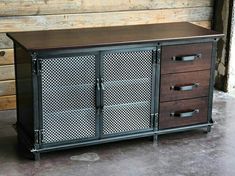 a metal cabinet with three drawers in front of a wooden wall