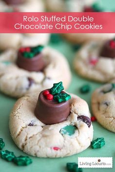 cookies decorated with chocolate and candy are on a green surface, surrounded by christmas decorations