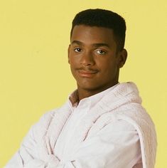 a man in a white robe is posing for a photo with his arms folded out