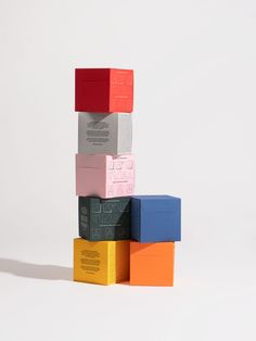 a stack of colorful blocks sitting on top of each other in front of a white background