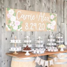 a wooden table topped with lots of cupcakes next to a sign that says cartie and alex