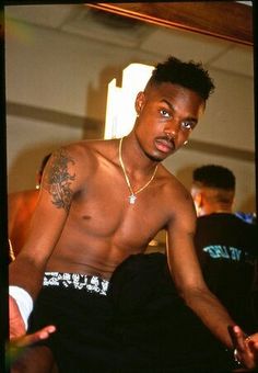 a young man with no shirt on standing in front of a mirror looking at the camera