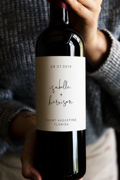 a person holding a bottle of wine in their left hand with the label on it