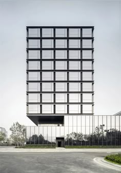 an empty parking lot in front of a tall building with lots of windows on it