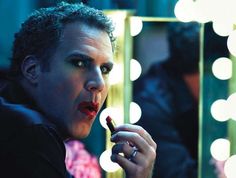 a man with curly hair holding a lipstick in front of a mirror