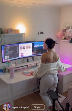 a woman sitting at a desk with two computer monitors