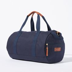 Sporty pals, we’ve had our not-so-sporty-bags stolen just one too many times, so we made you your own. Fabricated of our durable yet lightweight 12 oz canvas and accented with tonal navy webbing this is the perfect grab and go bag. A pair of sneakers, change of clothes, and shower essentials and we’ll have you from the gym to the office in no time. Carry the duffle with the handles or sling it over your shoulder with the removable strap. Functional Weekender Bag With Leather Trim, Sporty Canvas Travel Bag, Sporty Everyday Canvas Bag, Functional Coated Canvas Bag For Everyday Use, Casual Navy Bag For Outdoor, Casual Navy Bags For Outdoor, Functional Everyday Coated Canvas Bag, Casual Navy Outdoor Bag, Sporty Canvas Gym Bag For Travel